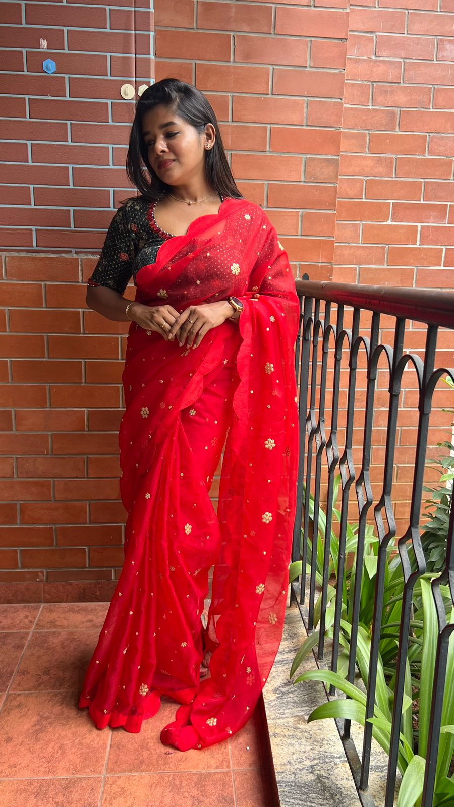 Red organza saree with greenish black handwork blouse