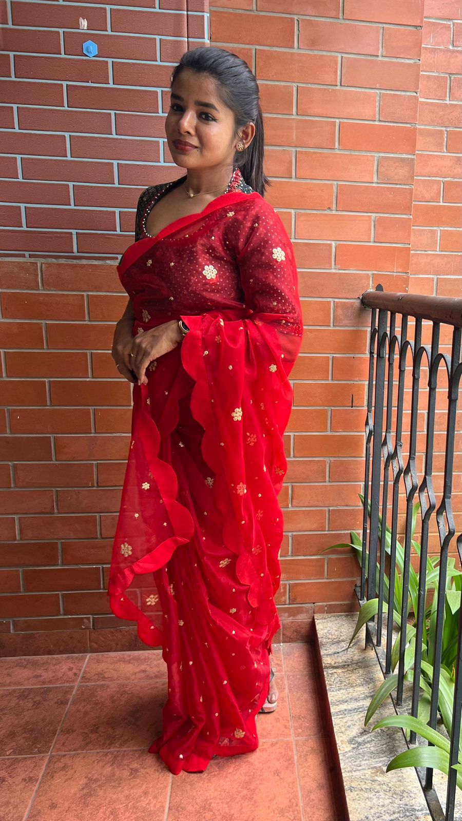 Red organza saree with greenish black handwork blouse
