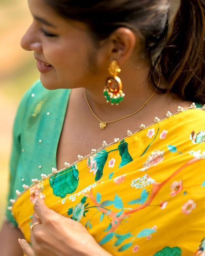 Yellow floral saree with green hand worked blouse