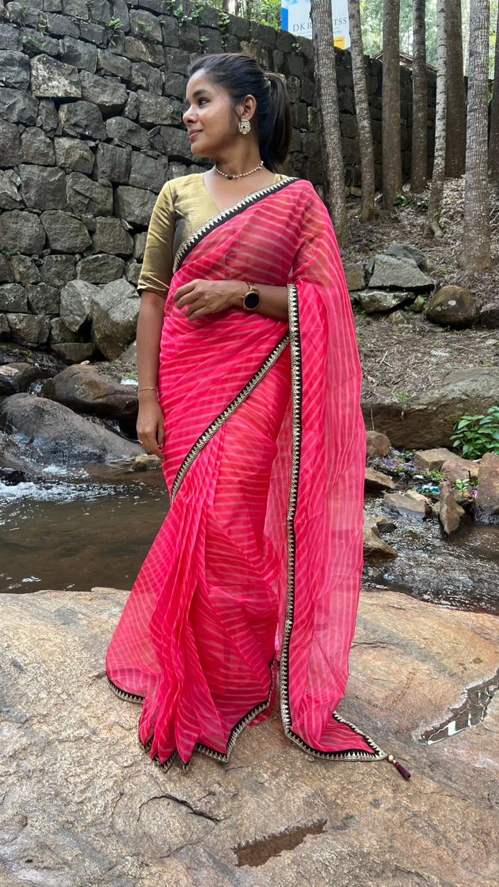 Pink stripped organza saree with black & gold blouse
