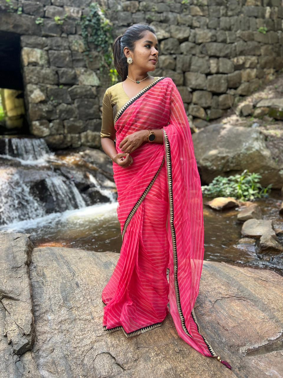 Pink stripped organza saree with black & gold blouse